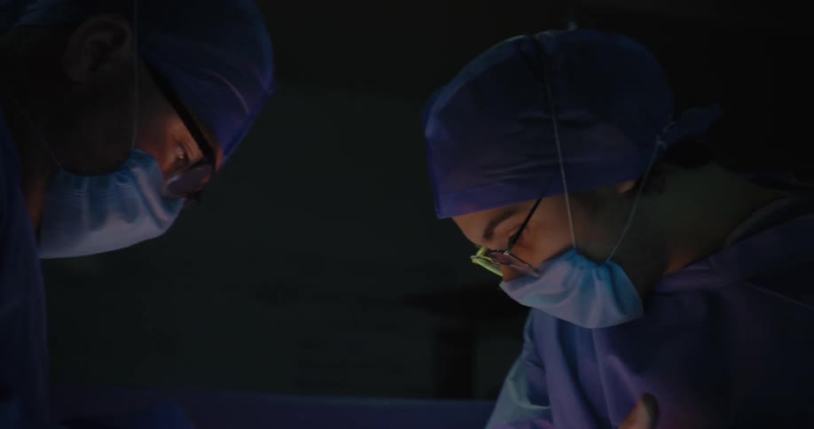 Close up of two surgeons performing a surgery in an operating theatre