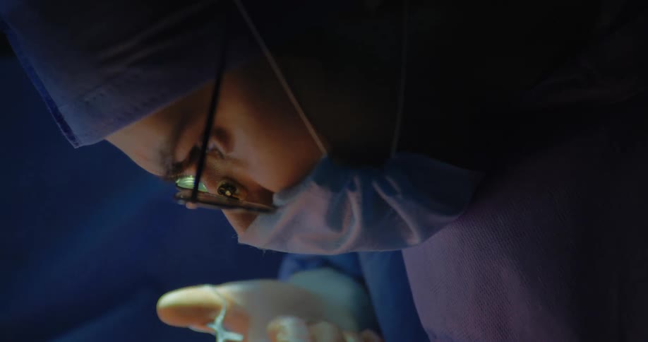 Side portrait of a female doctor concentrating on a surgical procedure