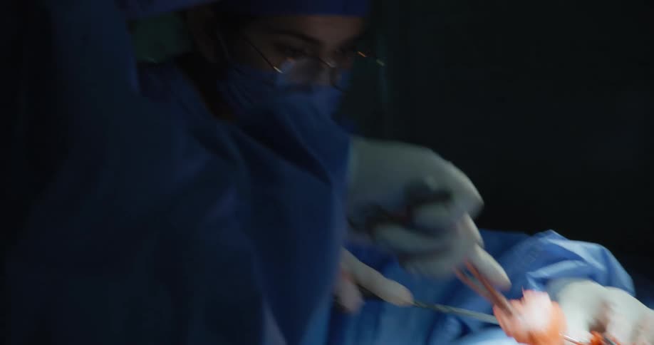 Doctors performing a surgical procedure with a patient lying down