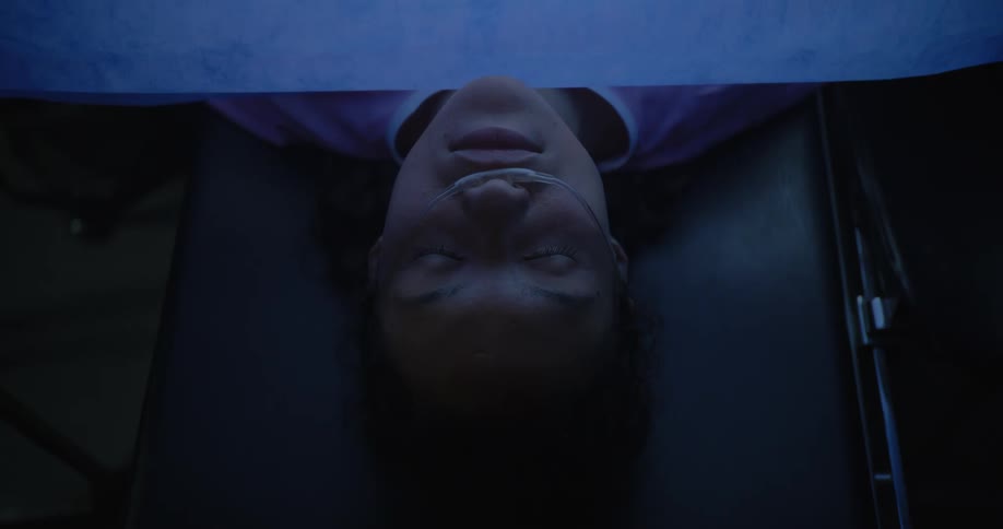 Close up portrait of a female patient lying under anaesthesia on an operational theatre bed in the hospital