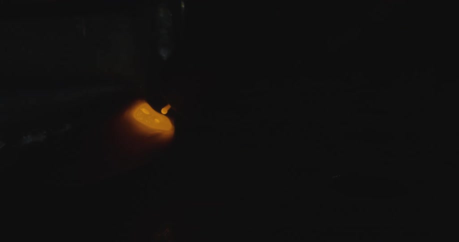 Sparks fly in the dark as molten metal is worked or welded