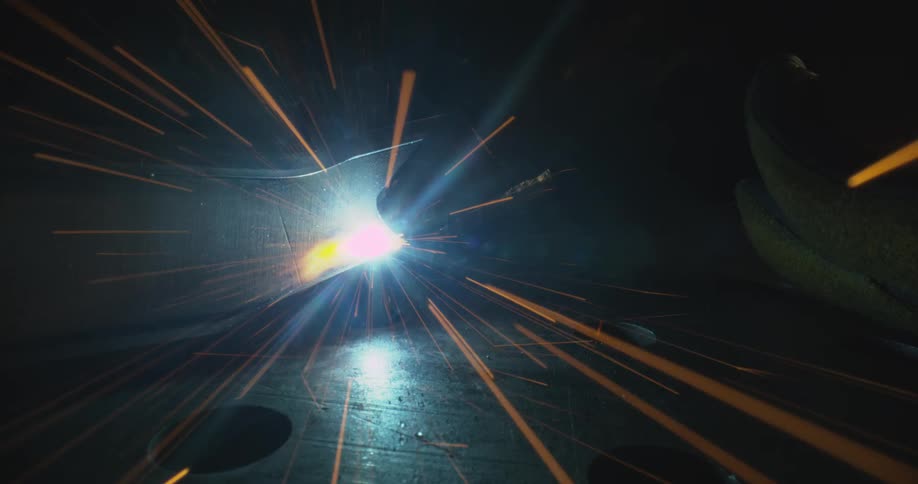 Welding pipe on a metal giving off sparks