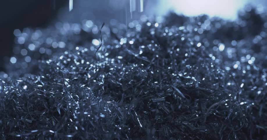 Metal shavings fall and bounce in a pile