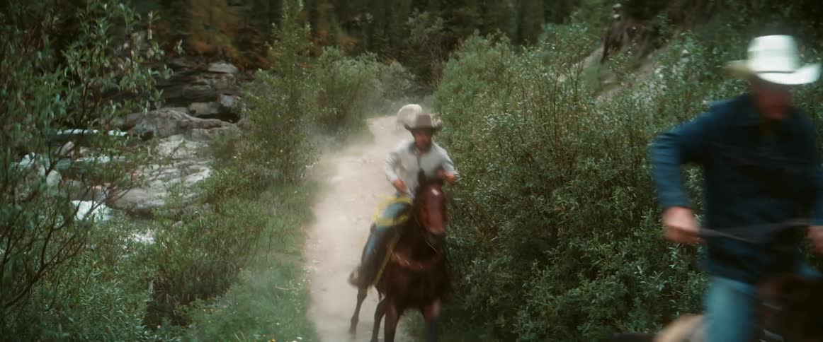 Men riding horses along a trail