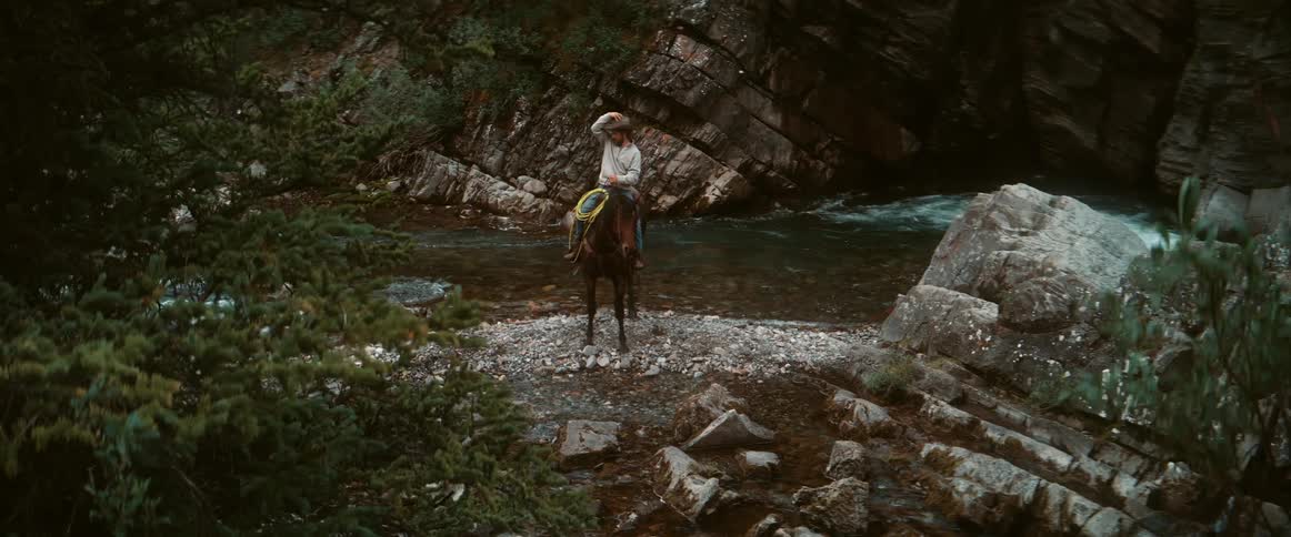 The man stops on his horse by the water