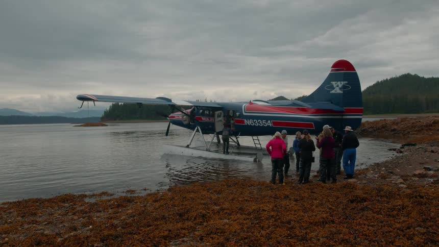 Group of people at the seaside with a water plane next to them