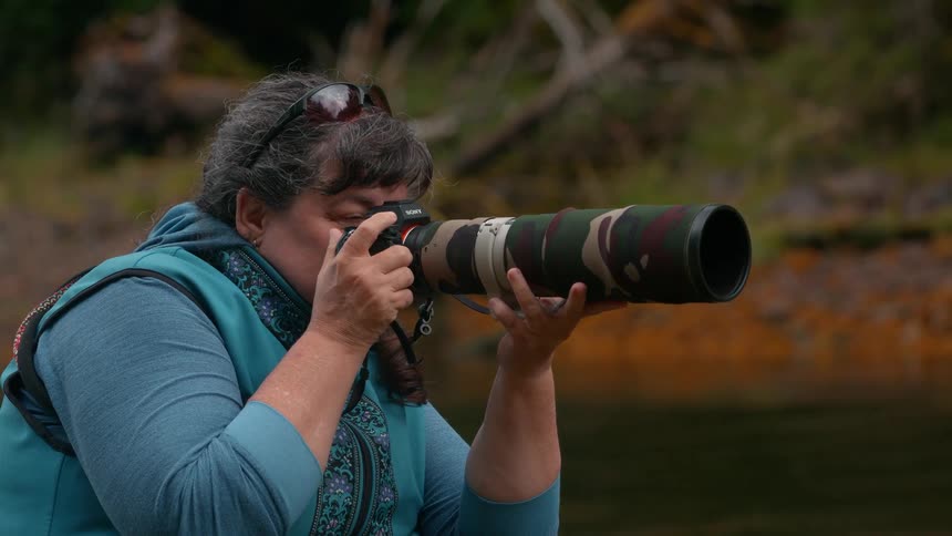 Photographer with a long lenses camera taking pictures of the wilderness