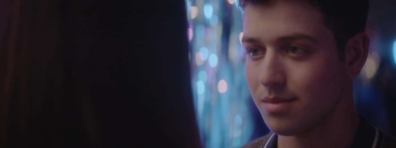 A young boy stares while people dance at a party