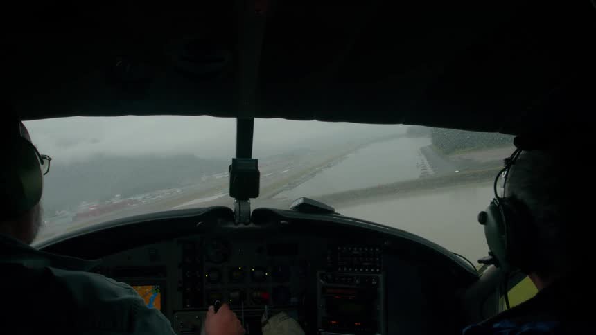 Silhouette of two people in the cockpit of a helicopter