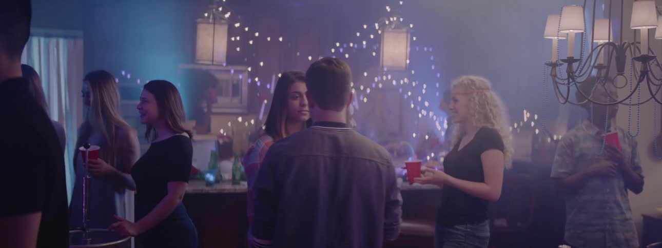 Two teenagers kiss at a party