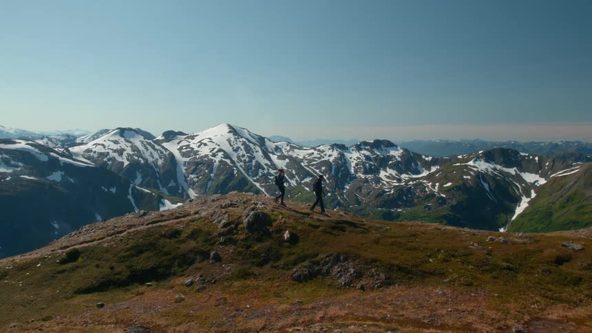Two people hiking together on mountainous terrain