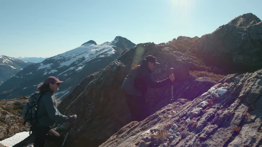 A man and woman hike up a mountain