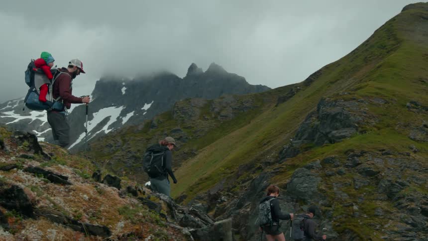 Group of people descending a mountain on a cloudy day