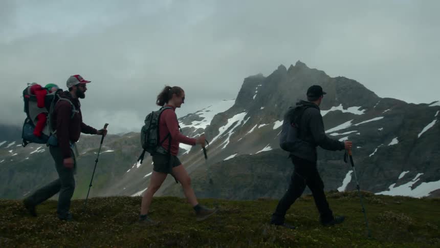 A group of hikers trek along a misty mountain ridge
