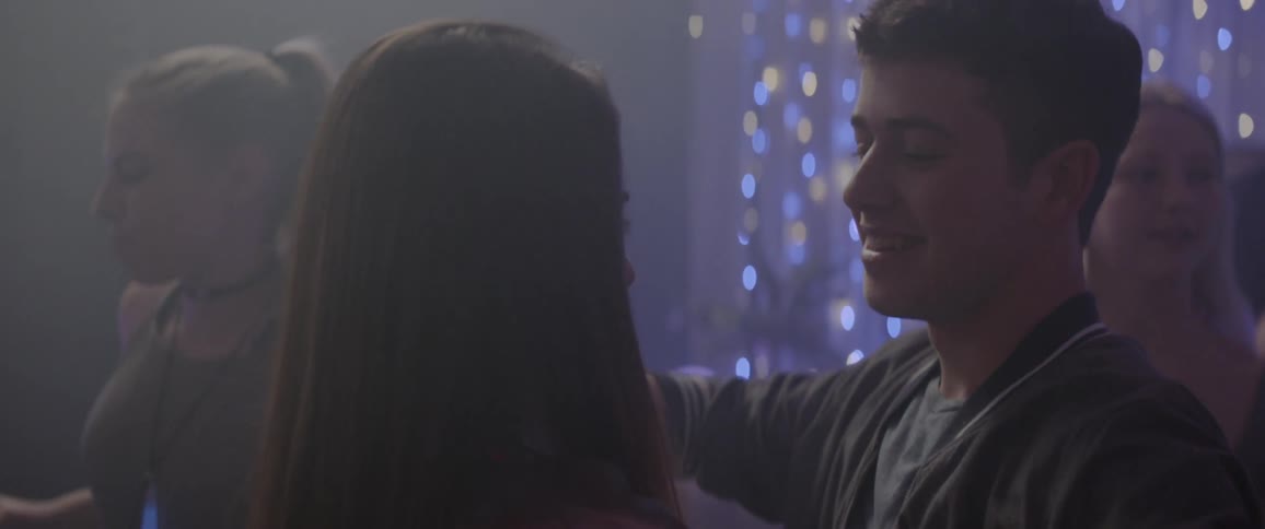 Two teenagers dance at a house party