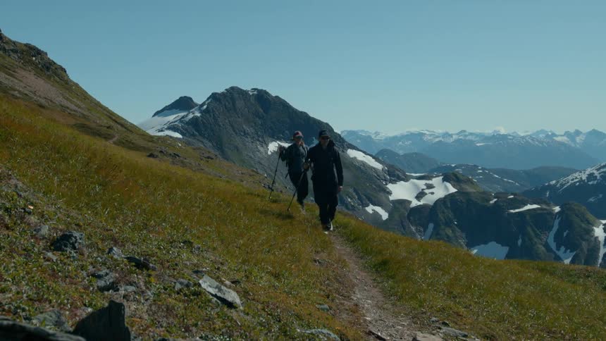 Two people hiking along a scenic mountain trail