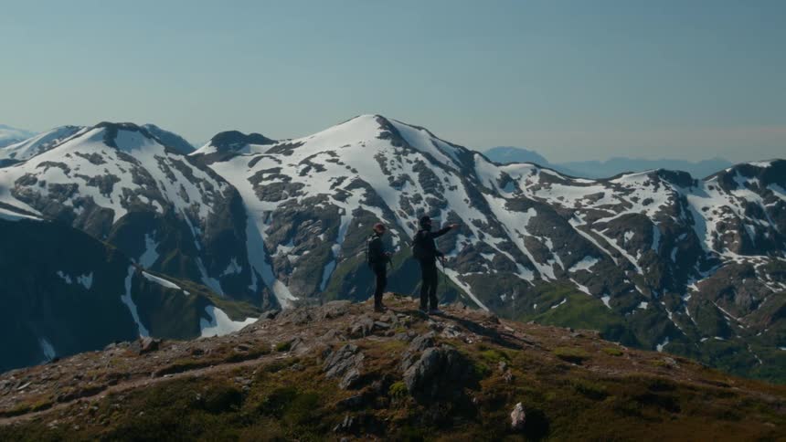 Two travelers on a snowy mountain peak