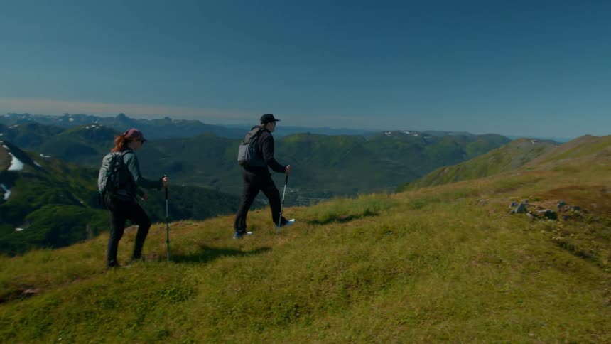 Two hikers reach the peak of the mountain