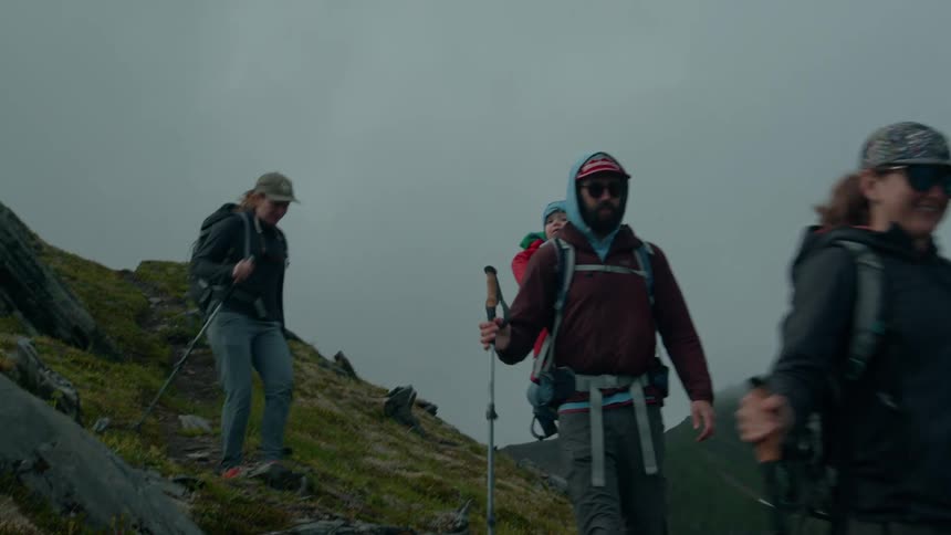Group of people hiking up a mountain on a cloudy day