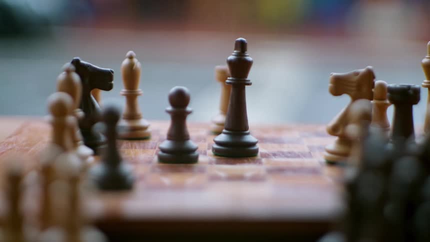 Close up of chess board with people playing