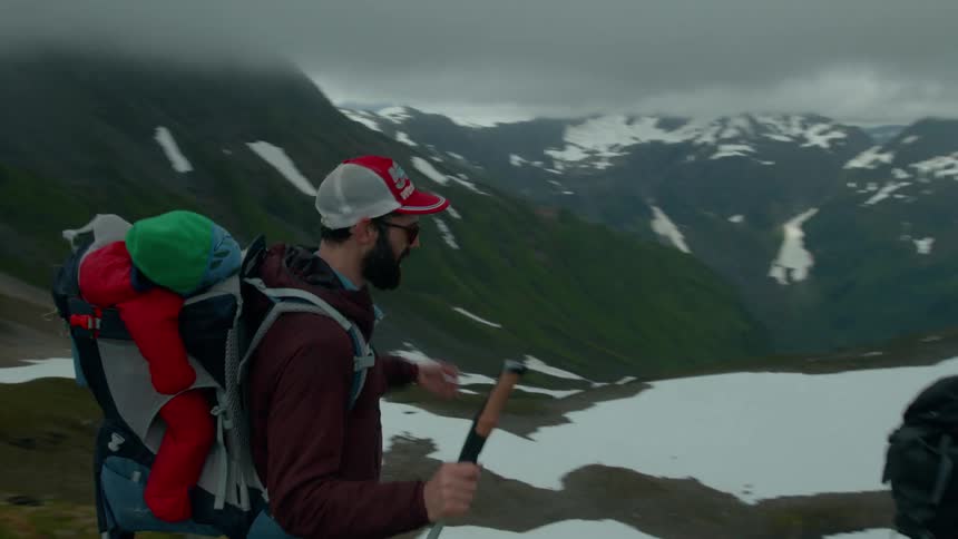 Group of hikers are walking downhill a snowy mountain
