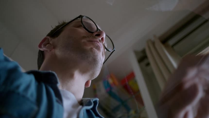 Man with glasses sitting in an indoor area
