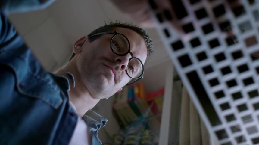 A man sitting in a room typing on a computer keyboard