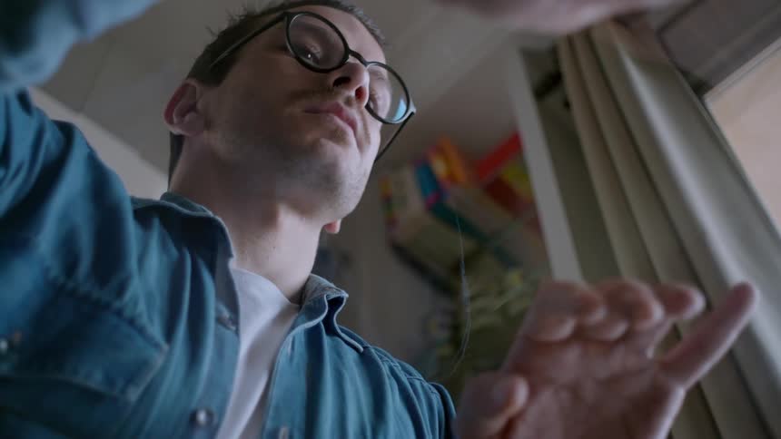 Man with glasses seen through a glass table