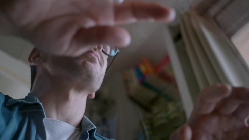 Bottom view of a man wearing glasses with his hands on a table