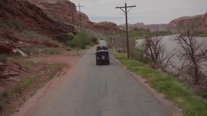 A loaded vehicle travels the road beside a river