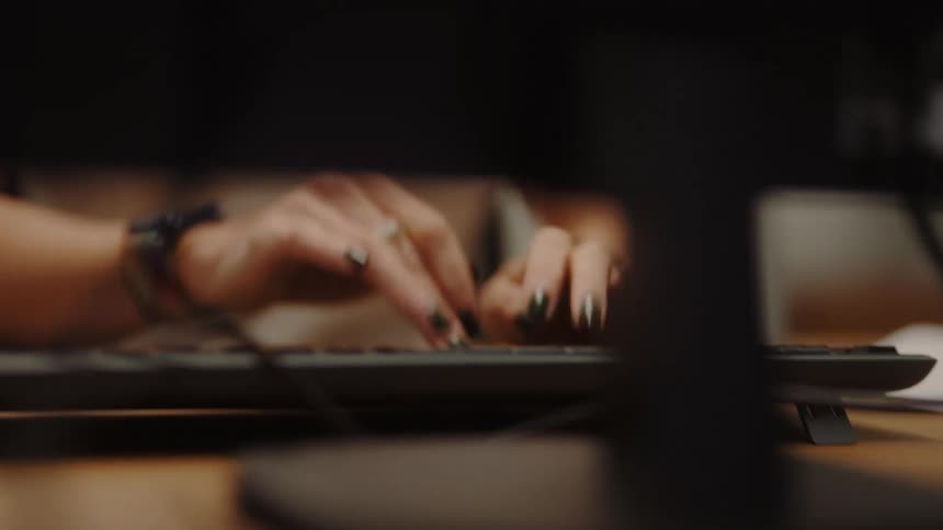 Person typing on a computer keyboard at a workstation