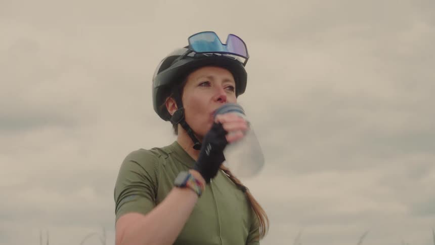 A biker takes a break to hydrate with bottled water