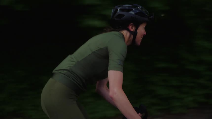 A woman cycling on a road outdoors during daytime
