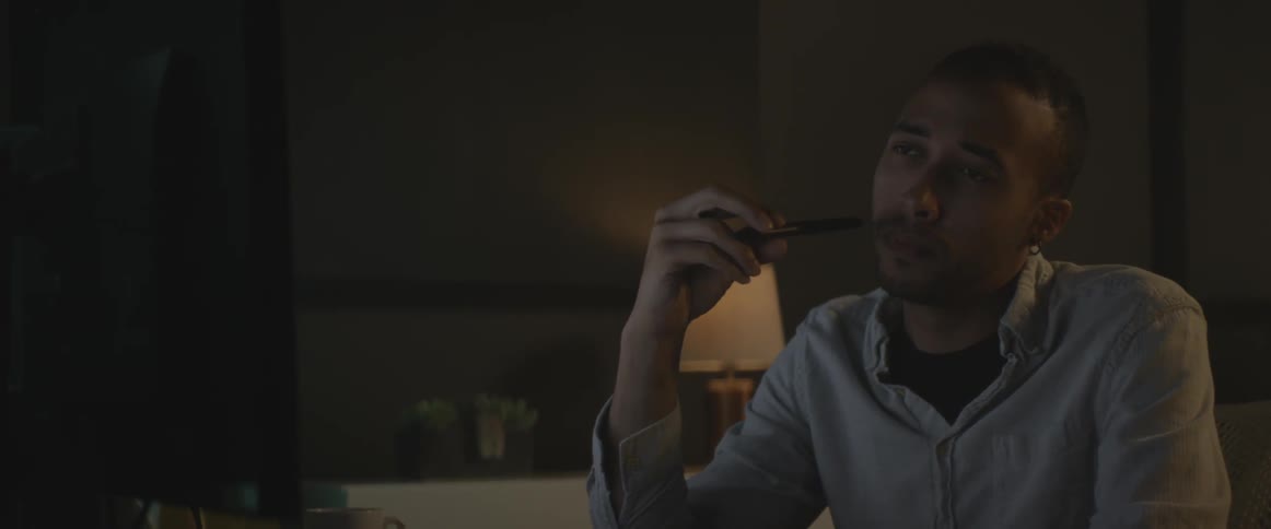 A man takes a drink from a white mug