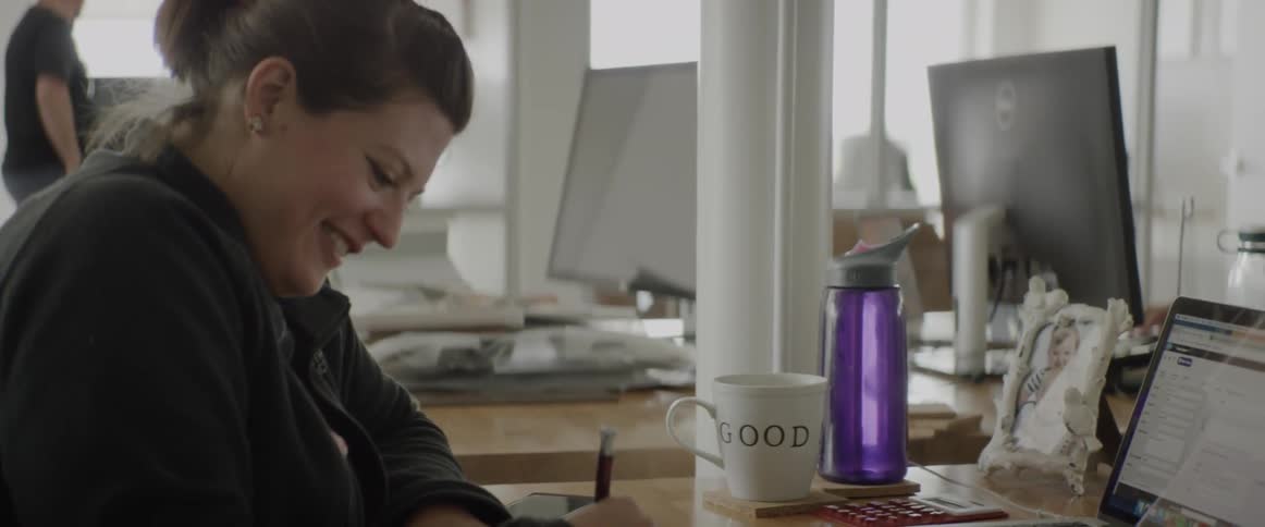 A woman works at a desk with a laptop