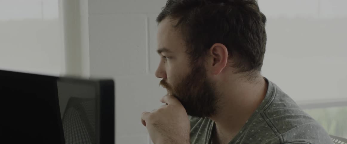 A man looks forward by a computer