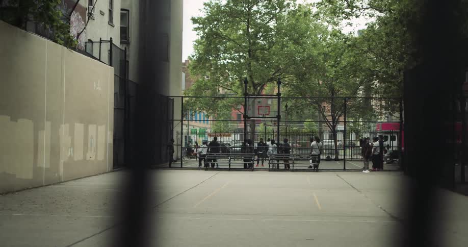 Group of people playing basketball on a court in an outdoor plaza