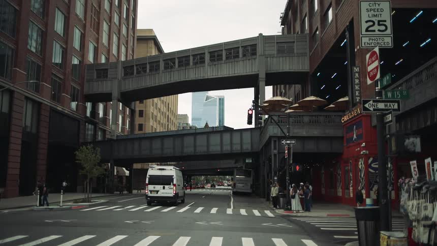 Urban street between buildings with vehicle and pedestrian traffic