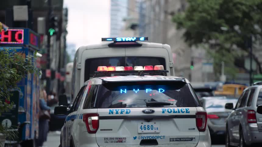 Police vehicles are parked on the side of the road