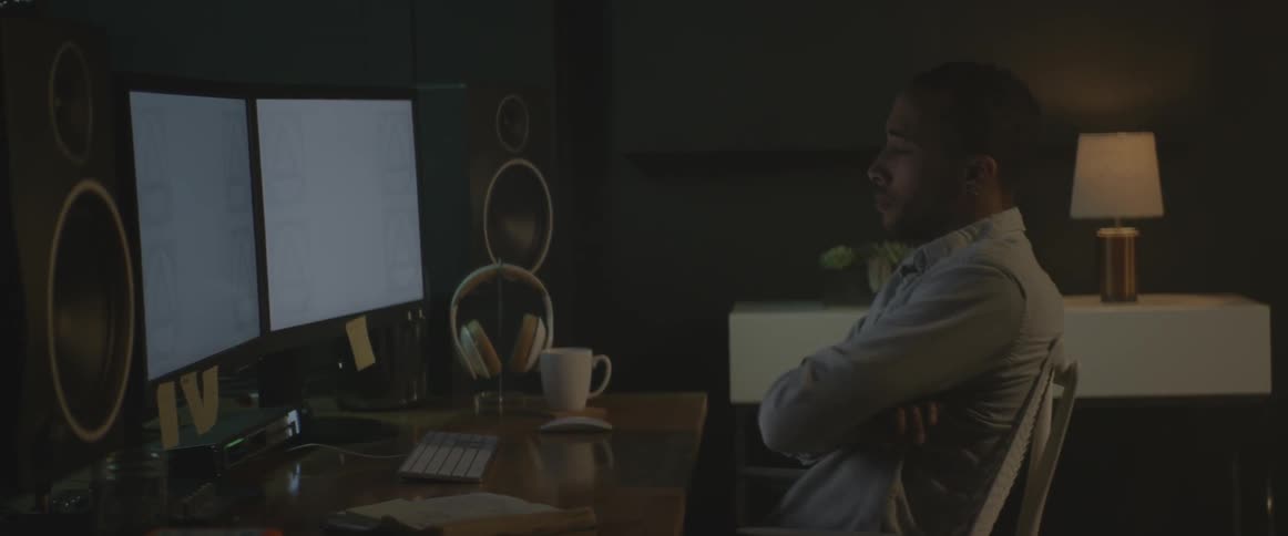 A man works at a desk with multiple monitors