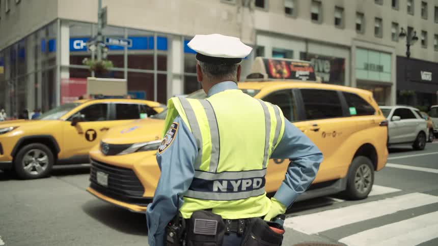 A police officer is standing by the crosswalk