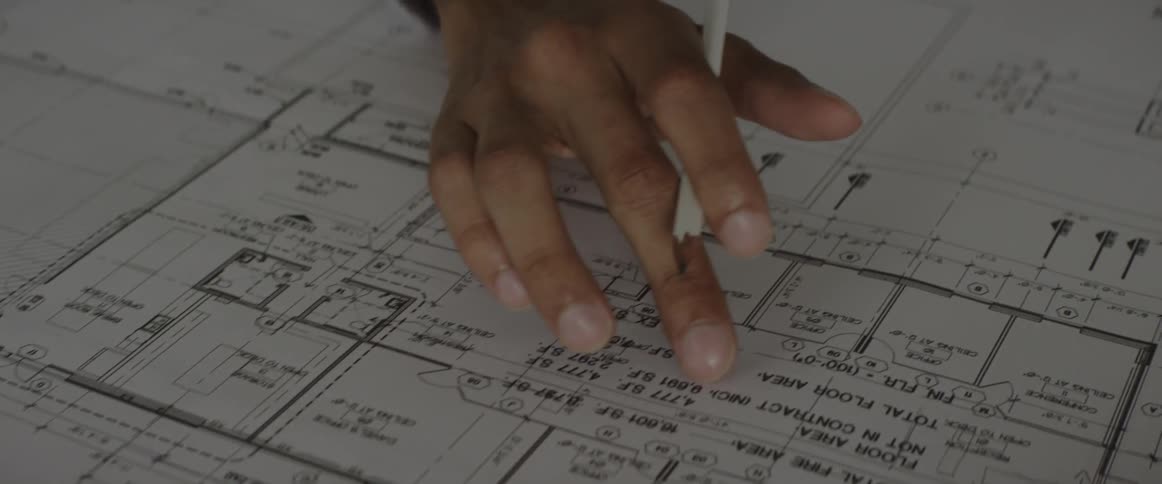 A person is looking over some blueprints