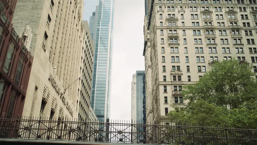 Some apartment buildings in a metropolitan city and some skyscrapers in the background