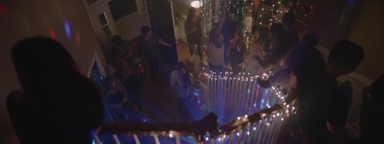 People dance in a brightly lit home