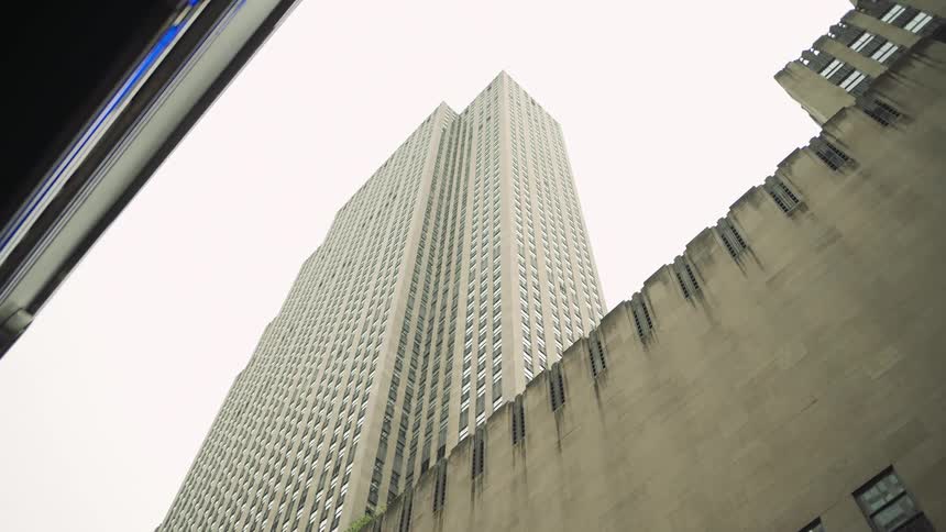 Upward view of a modern skyscraper against a cloudy sky