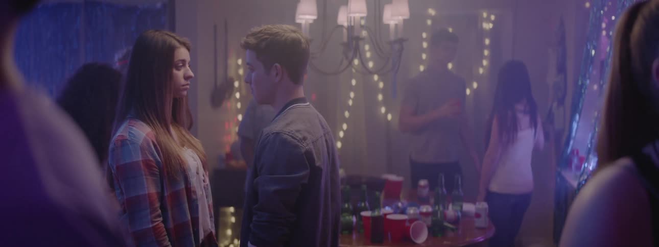 Two teenagers kiss at a house party