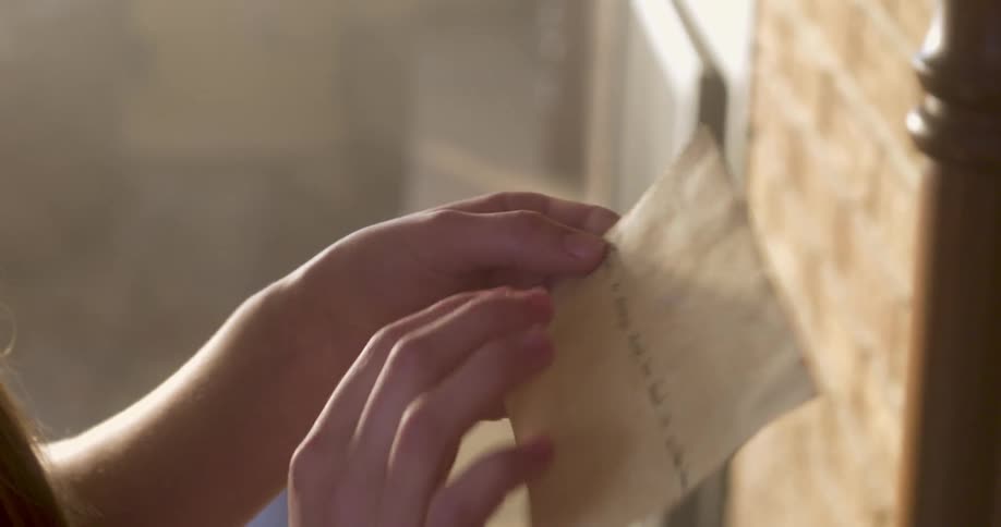 Woman pulling out a note on a card from shelf and smiling