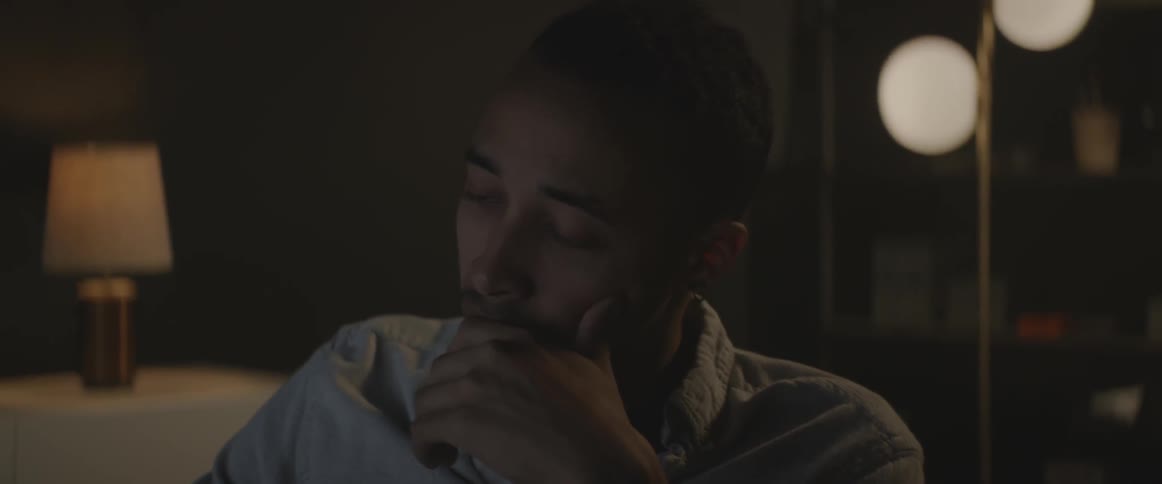 A man is looking down in a dark room