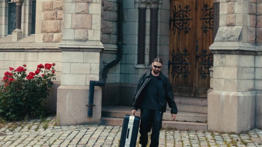 Man leaving a house with a suitcase