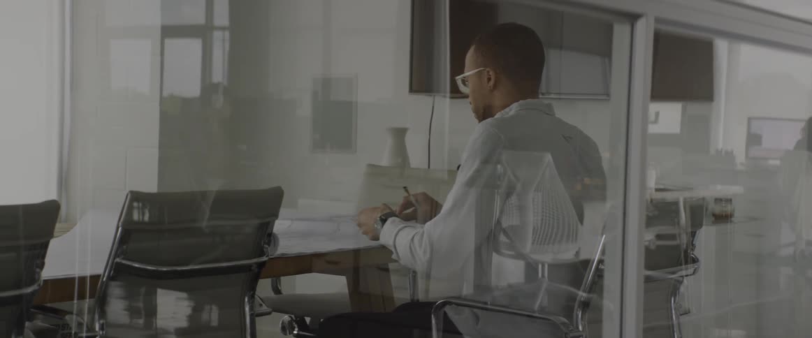 A man is flipping through blueprints in an office